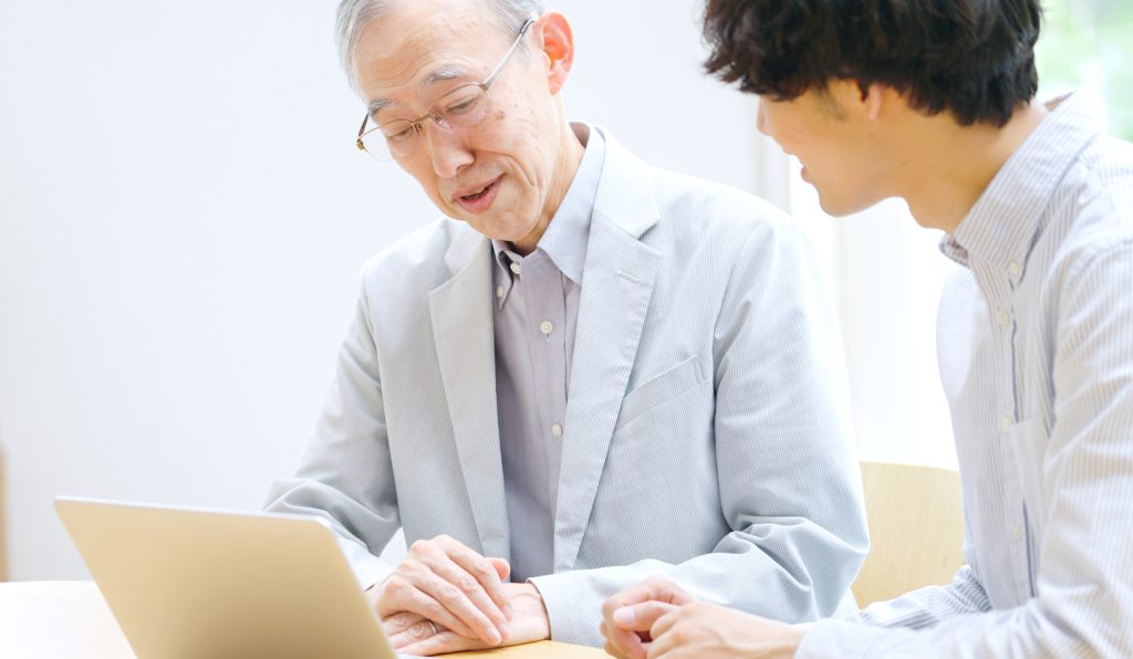 親子で取り組む遺言書の作成記事入りイメージ画像　高齢の父と息子の相談風景